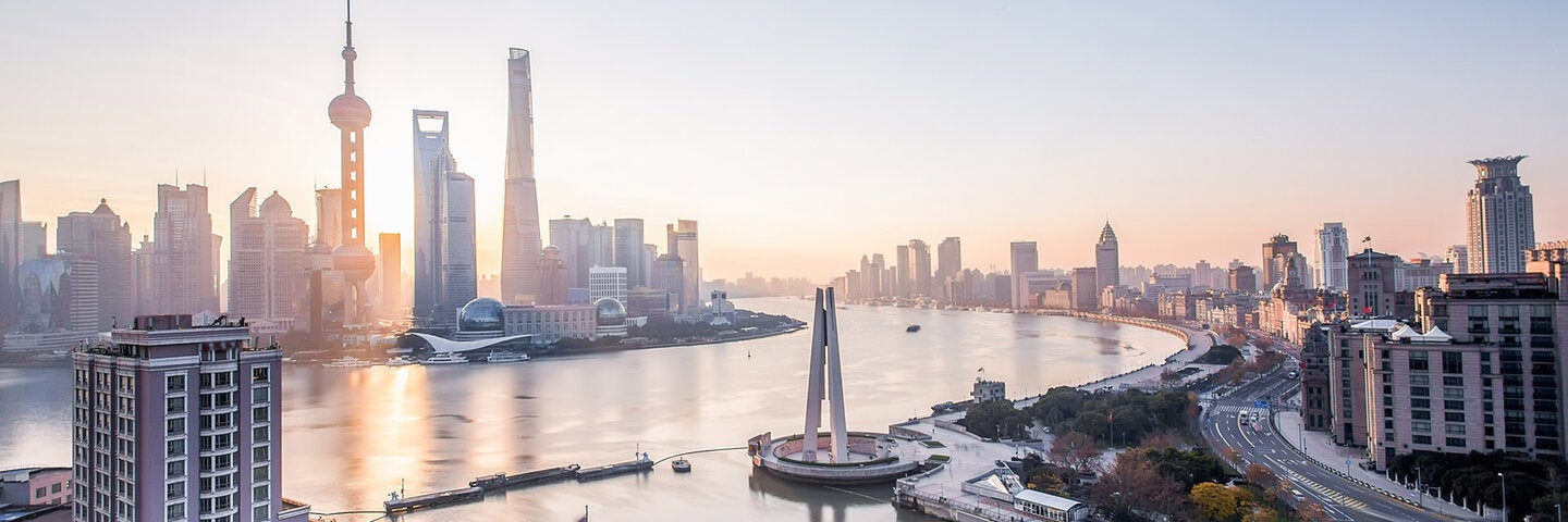 Shanghai Pudong sunrise over a city and river.