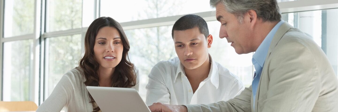 male and female couple with male advisor looking at computer