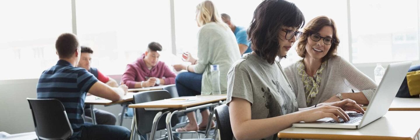 Advisor and adult student at laptop in classroom
