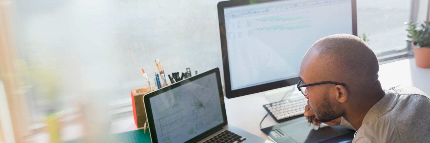 A man working on a CAD drawing on his laptop.