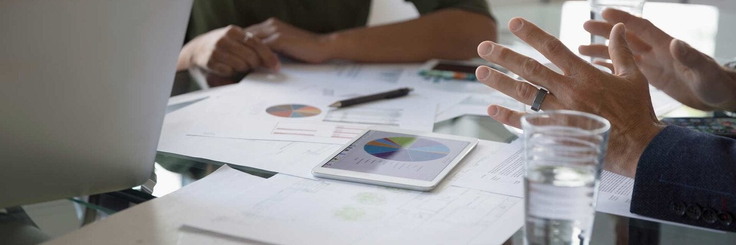Business people reviewing financial data paperwork in conference room meeting