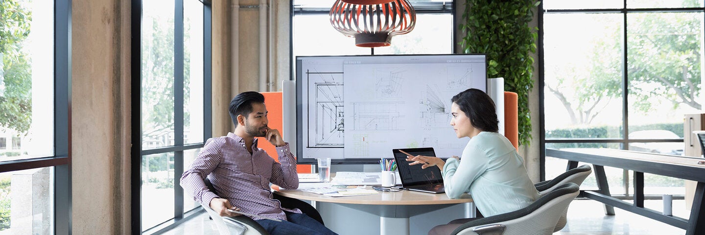 two business people sitting at a table discussing an issue