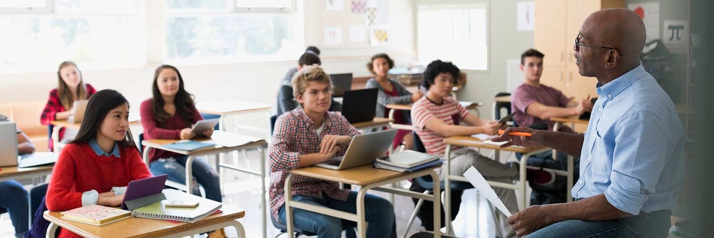 High school students listening to teacher in classroom