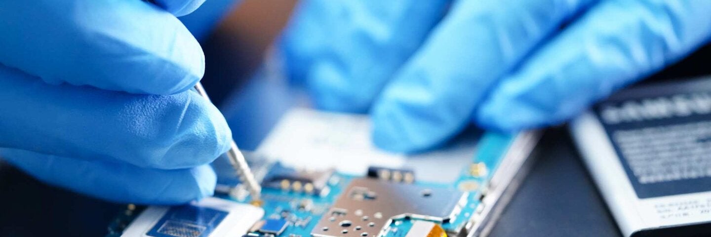 Person with latex gloves working on mobile circuitboard