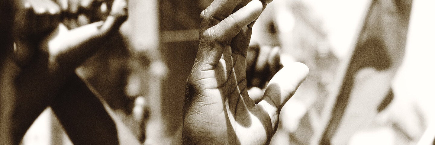 black and white image of hands raised in protest