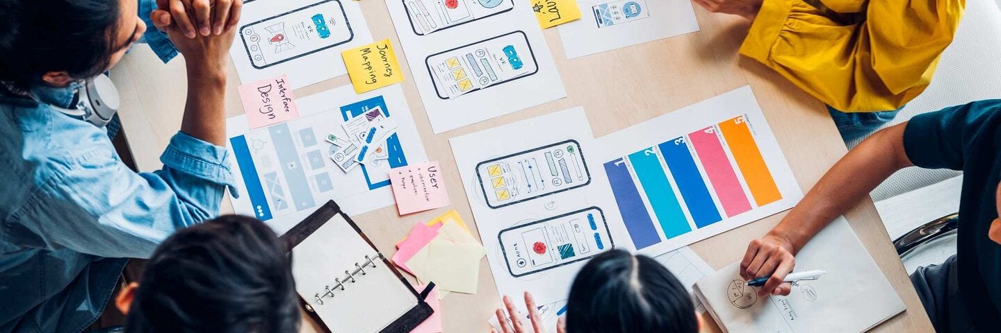 Students looking over UX layouts