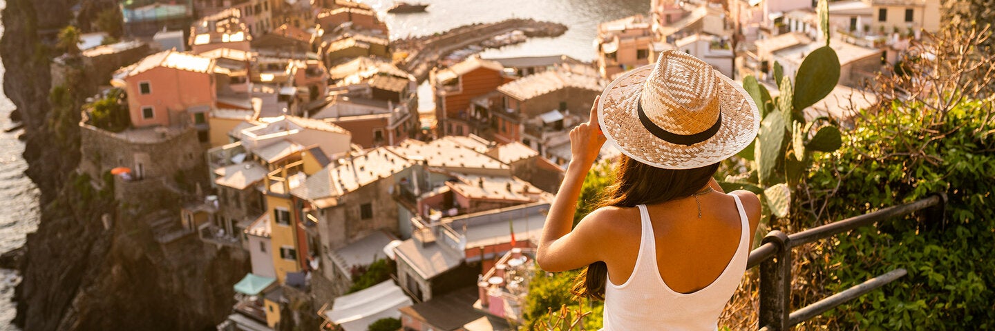 Woman taking a photo of a exotic village by the water