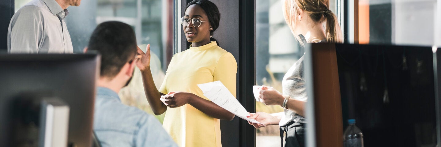 Professionals discussing ideas in an office, representing collaboration and leadership