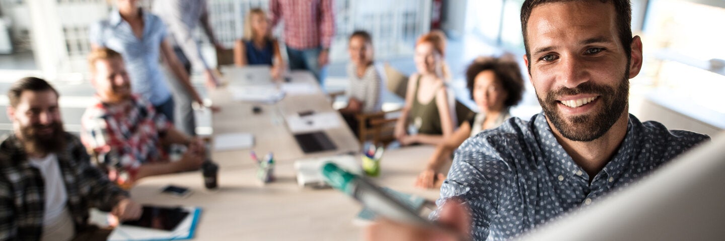 Person writing on the whiteboard in a meeting