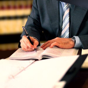 business man writing in a law library