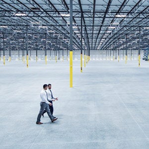Two business men in a large empty warehouse
