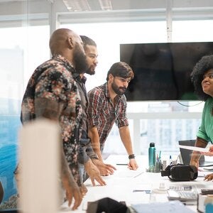 group of professionals standing around a conference table