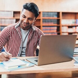 indian man studying with laptop
